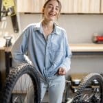 Handywoman reparing bicycle in the workshop